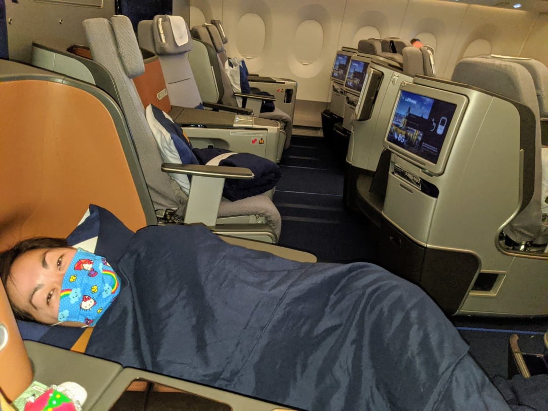 Chris lying down on business class flight