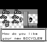 Pokémon Red bike shop frame showing the player standing across the counter from the clerk as the clerk asks, How do you like your new BICYCLE?