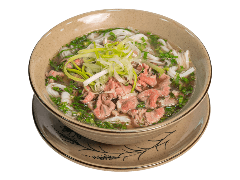一碗牛肉河粉,上面铺着牛肉片、葱花和切薄的洋葱丝