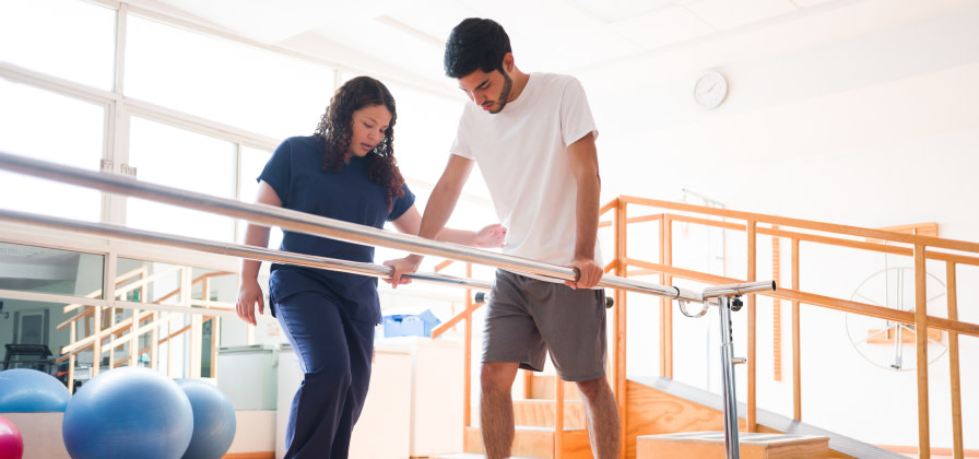 A physical therapist works with a patient on balance exercises