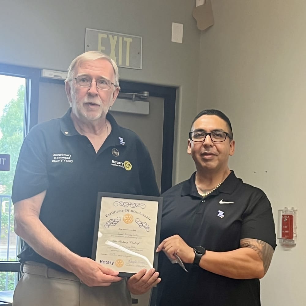 Sammy Bermudez Valdez receives a certificate of membership from President Doug Emery.