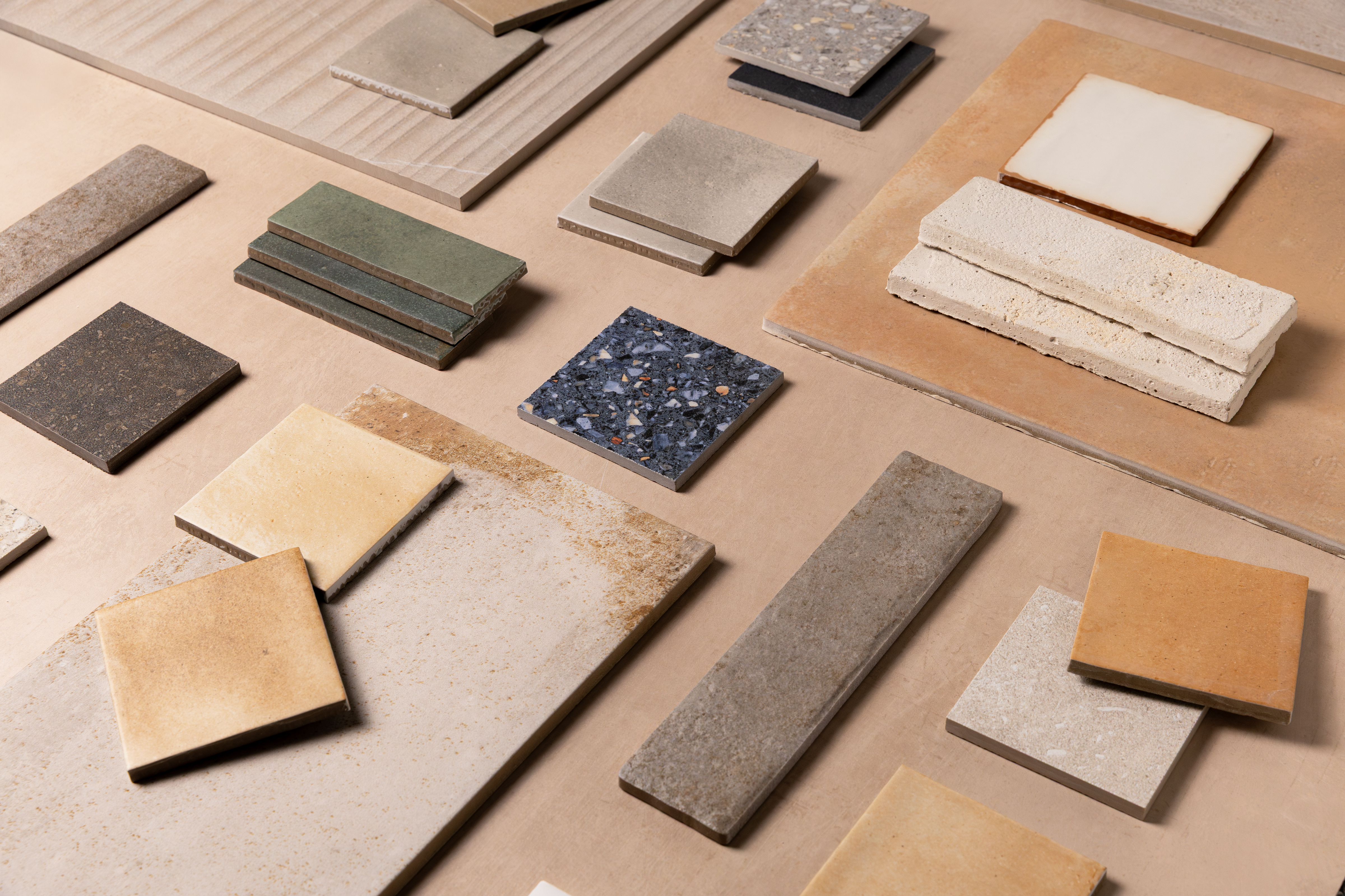 Assorted tile and stone samples arranged on a neutral background