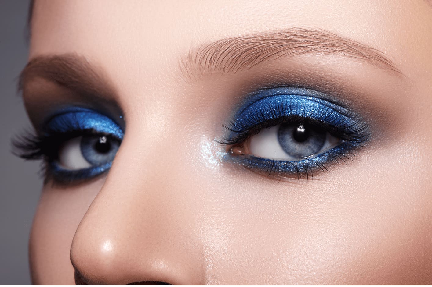 Imagem de olhos maquiados com sombra azul cintilante