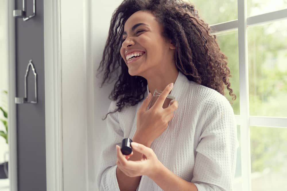 Imagem de mulher aplicando uma fragrância feminina