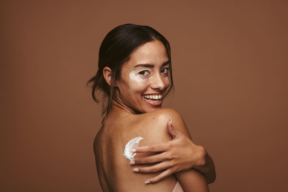 Imagem de mulher aplicando creme na pele