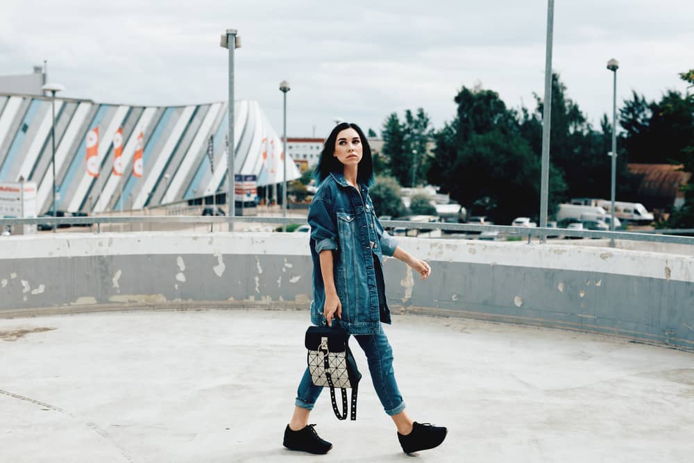 Imagem de mulher caminhando com jeans e tênis