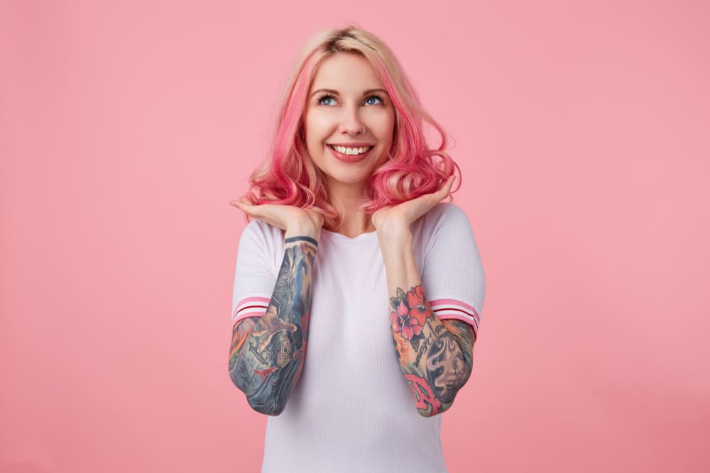 Imagem de mulher com cabelo colorido e pele tatuada