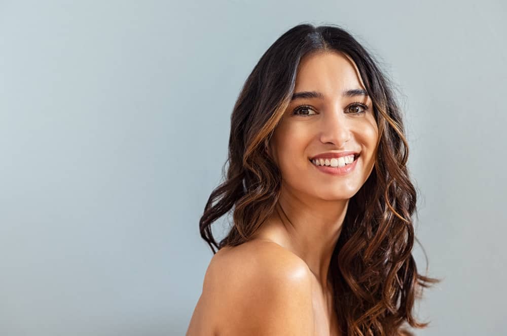 Mulher com cabelo ondulado, ela está sorrindo