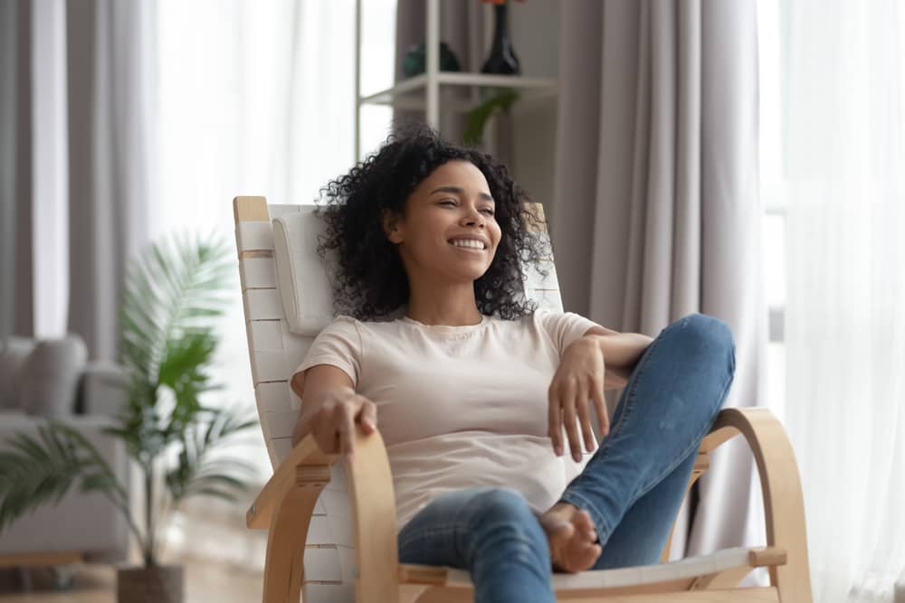 Mulher sentada em poltrona sorridente