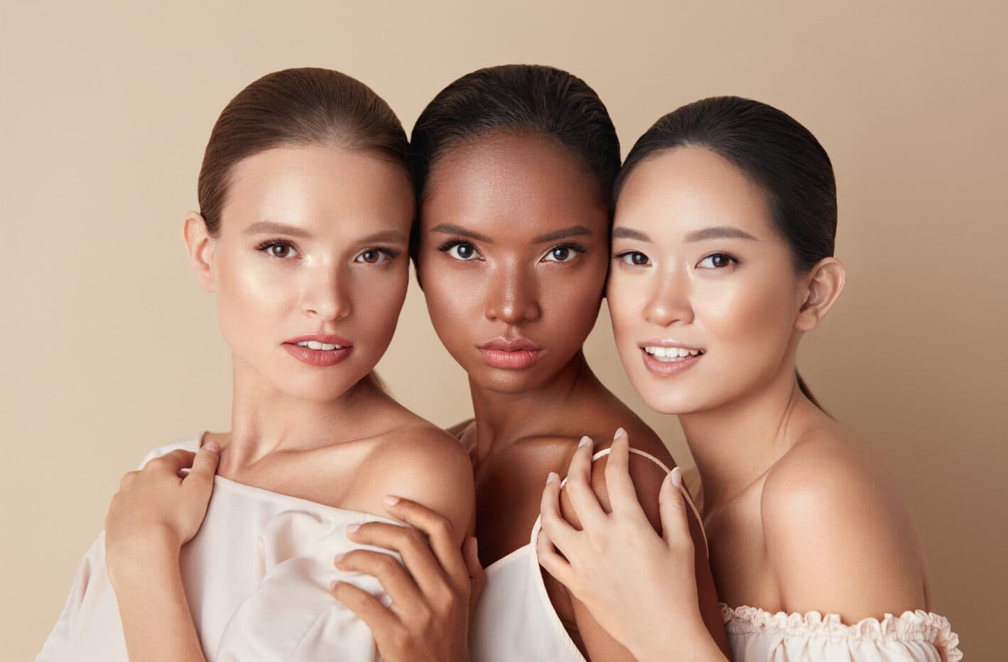 Imagem de 3 mulheres maquiadas com base, corretivo, iluminador, blush e pó compacto.