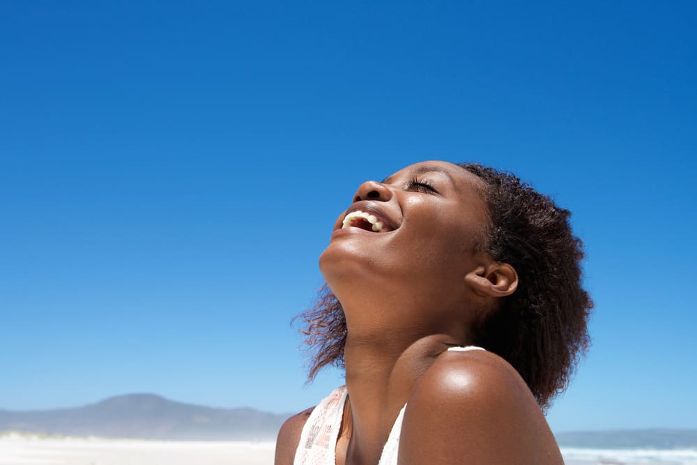 Imagem de mulher feliz na praia em um dia ensolarado