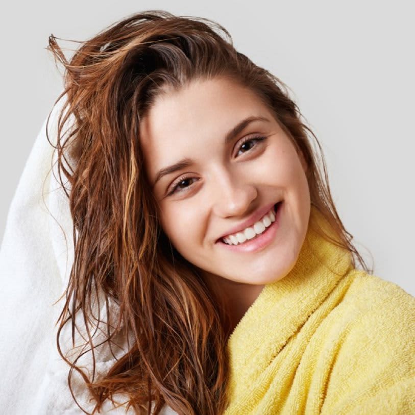 Mulher secando cabelo com uma toalha