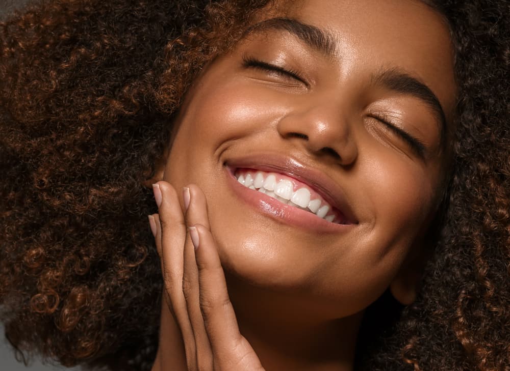 Imagem de mulher com maquiagem natural sorrindo