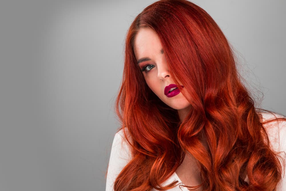 Imagem de mulher com cabelo ondulado em tom vermelho vibrante