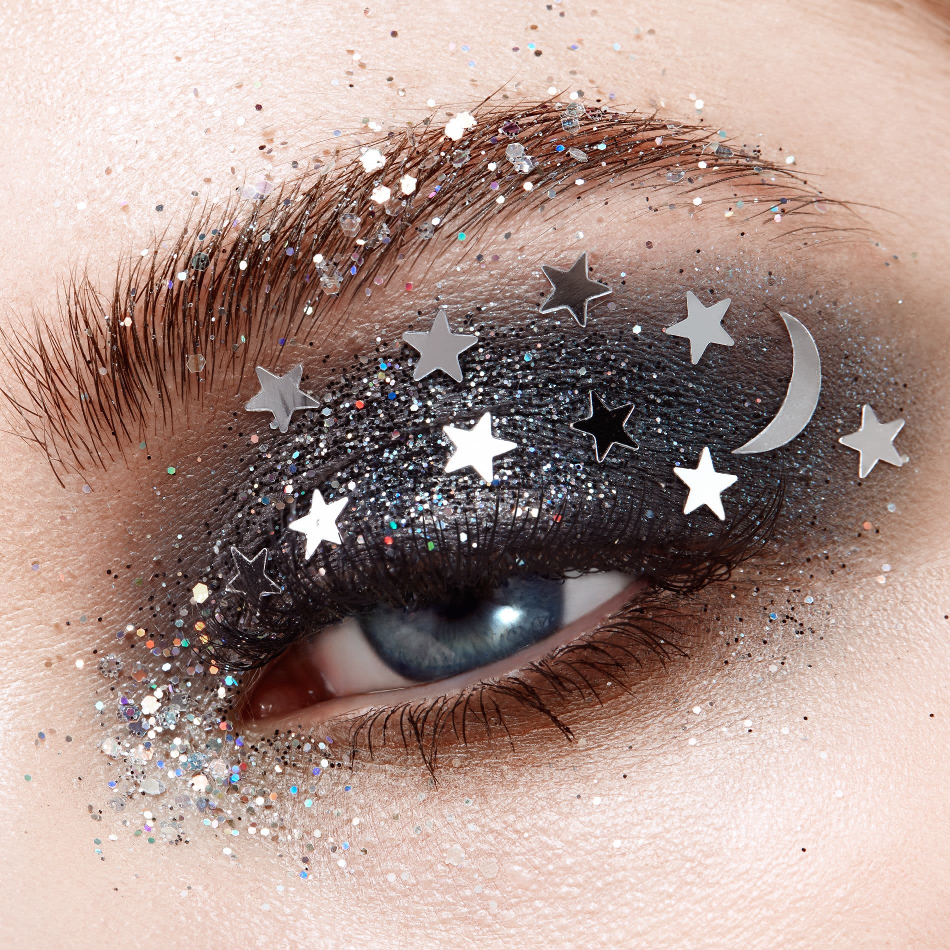 Olho maquiado com maquiagem prateada e glitter