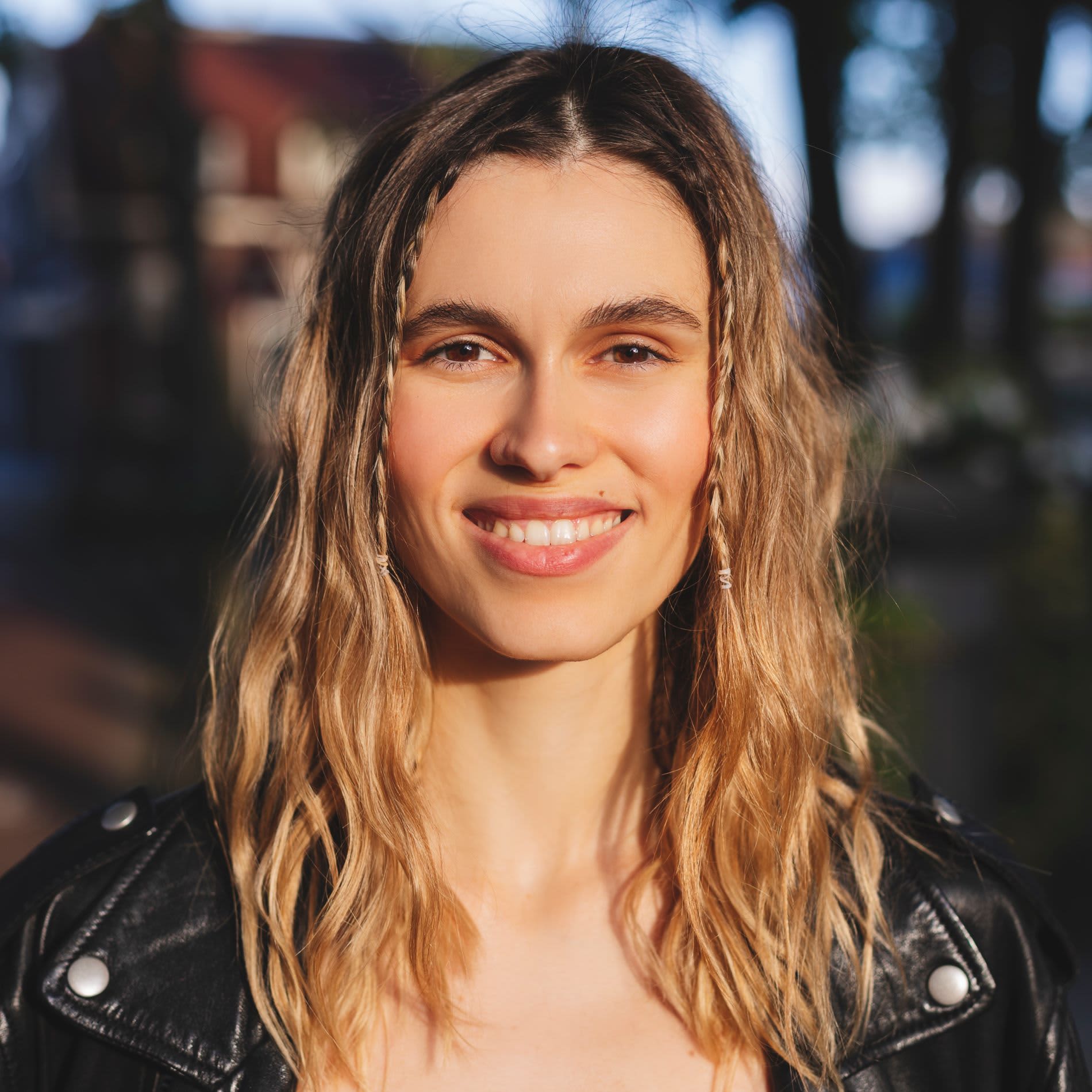 Mulher loira usando penteado com cabelo solto e pequenas tranças na parte da frente do cabelo.