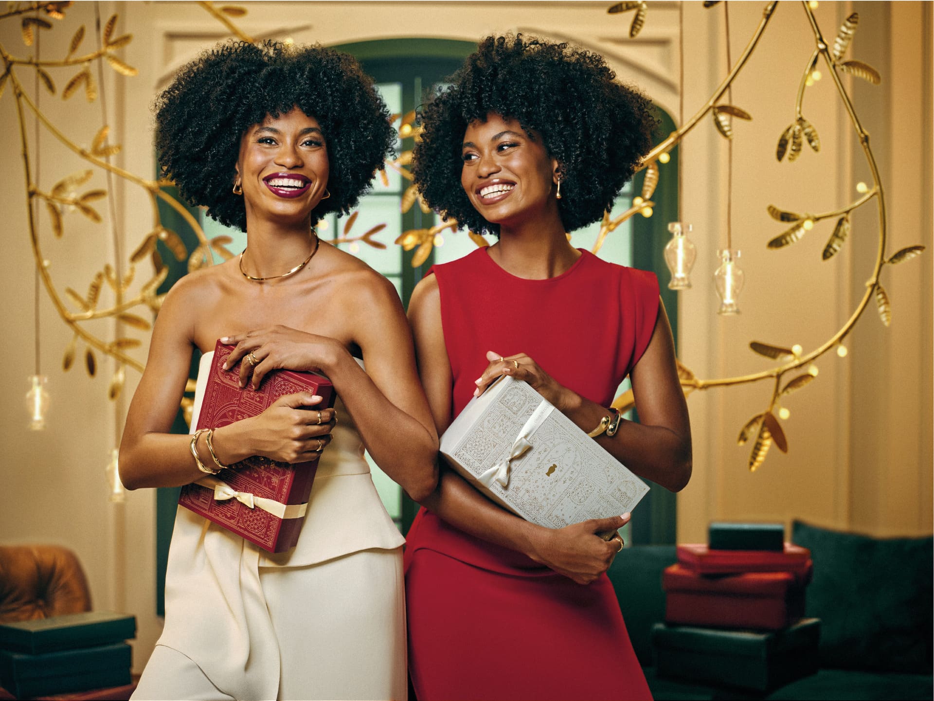 Duas mulheres sorrindo segurando caixas de presente