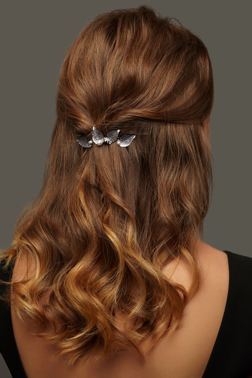 Mulher de costa exibindo cabelo meio preso