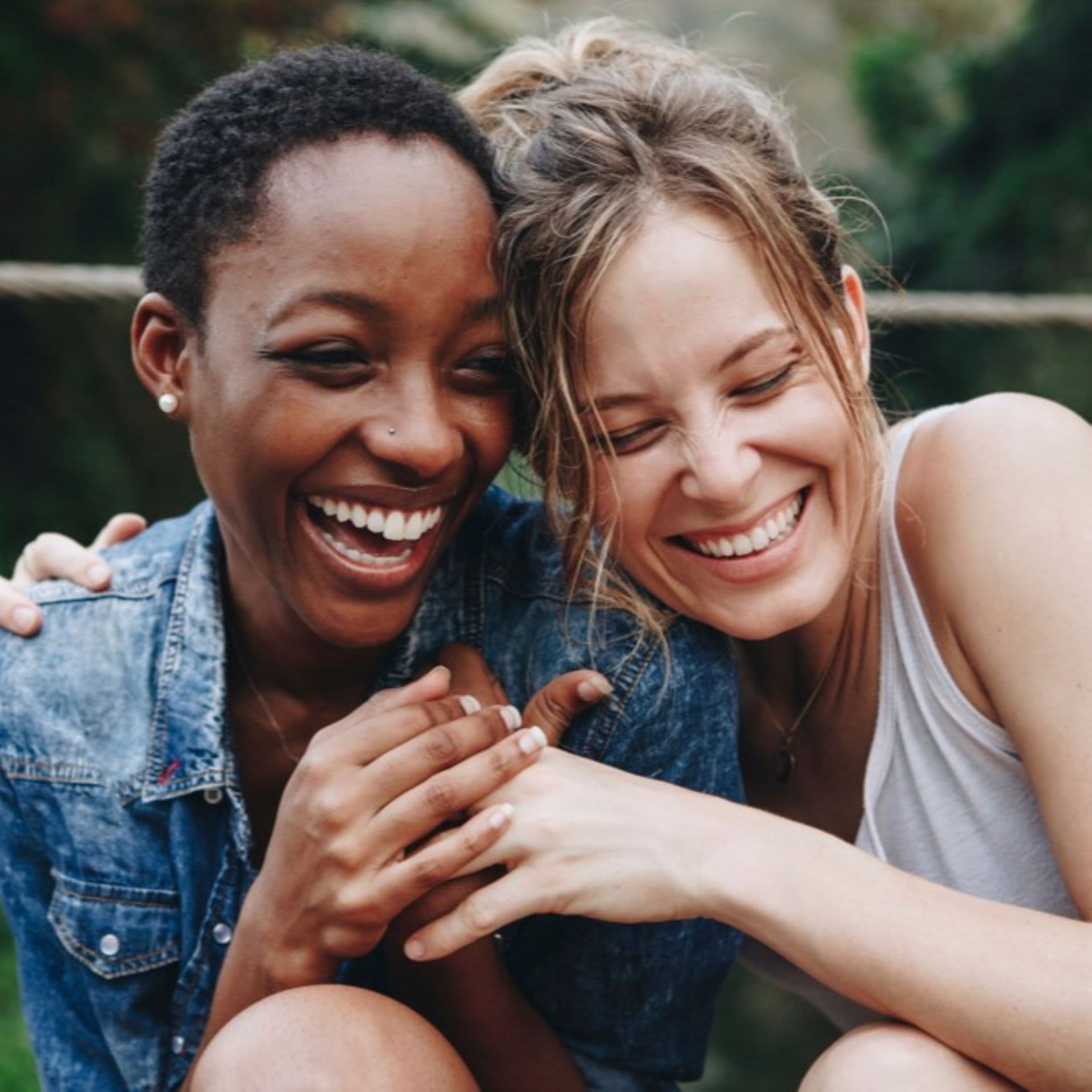 Duas mulheres sorrindo e se abraçando