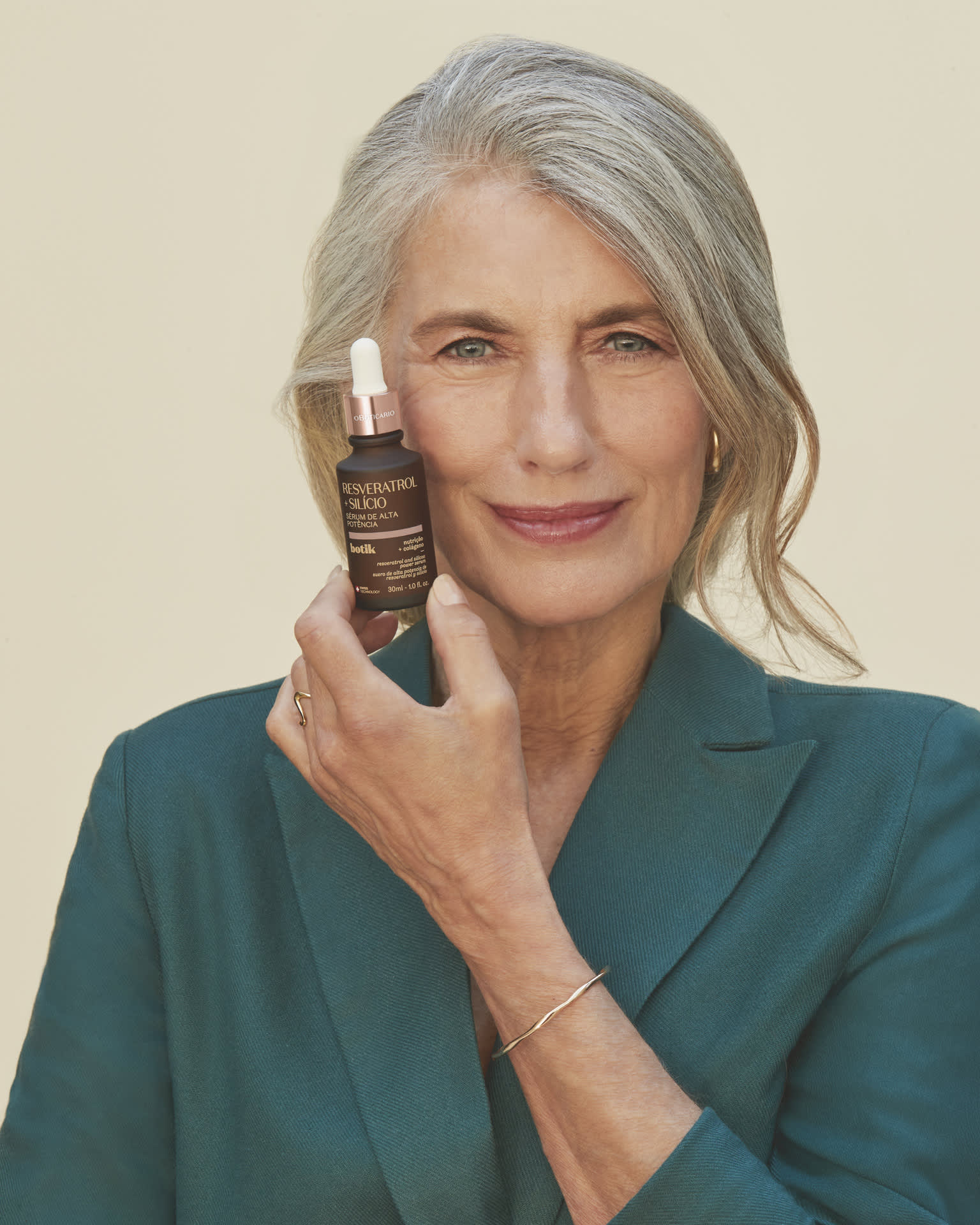 Mulher com pele madura segurando o sérum facial de Botik com Resveratrol