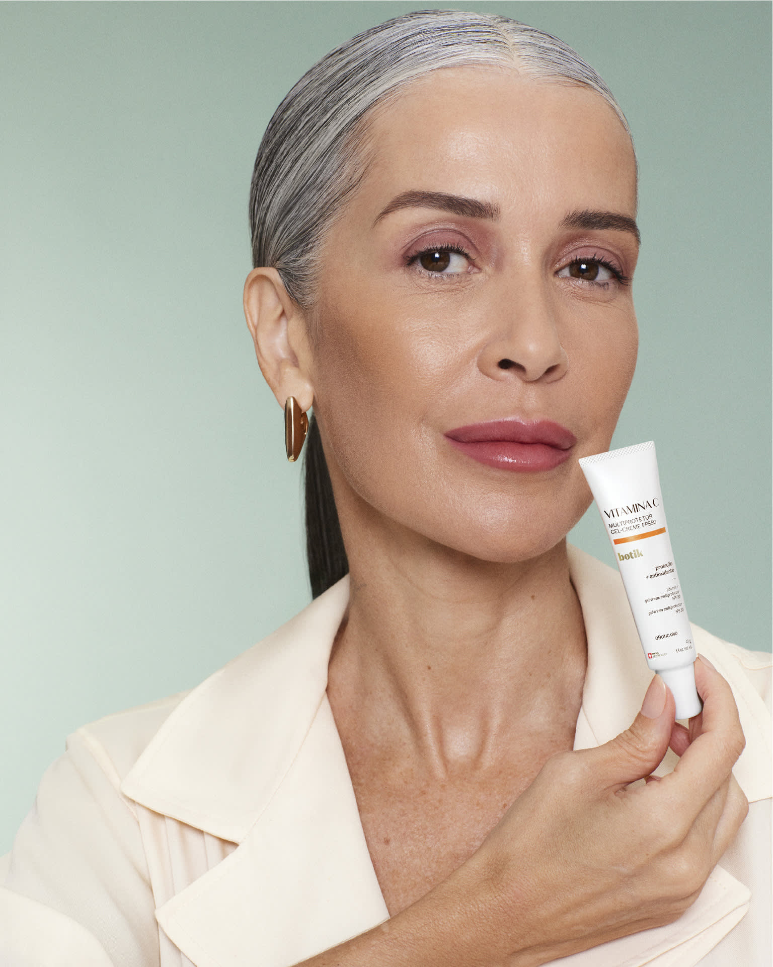 Mulher segurando creme multiprotetor de Botik