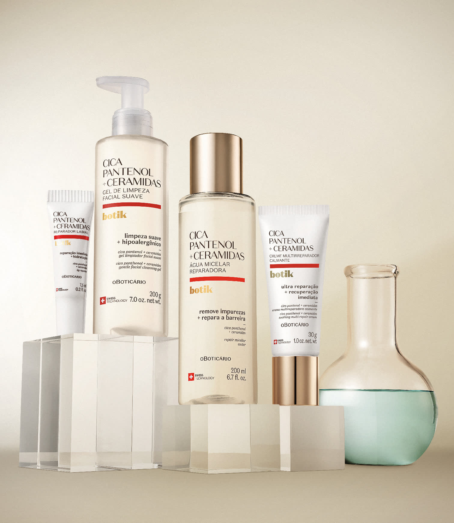 Quatro produtos da linha Botik Cica Pantenol + Ceramidas (gel de limpeza facial, água micelar, creme reparador e hidratante labial) dispostos sobre blocos transparentes, com um frasco de laboratório ao lado.