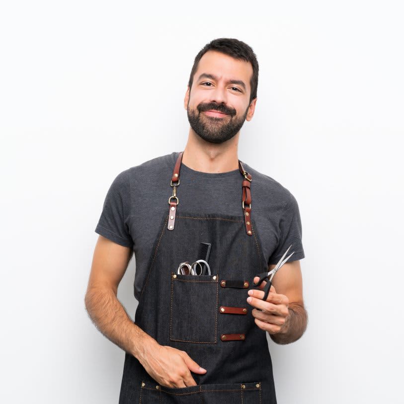 Homem usando avental com ferramentas de barbearia