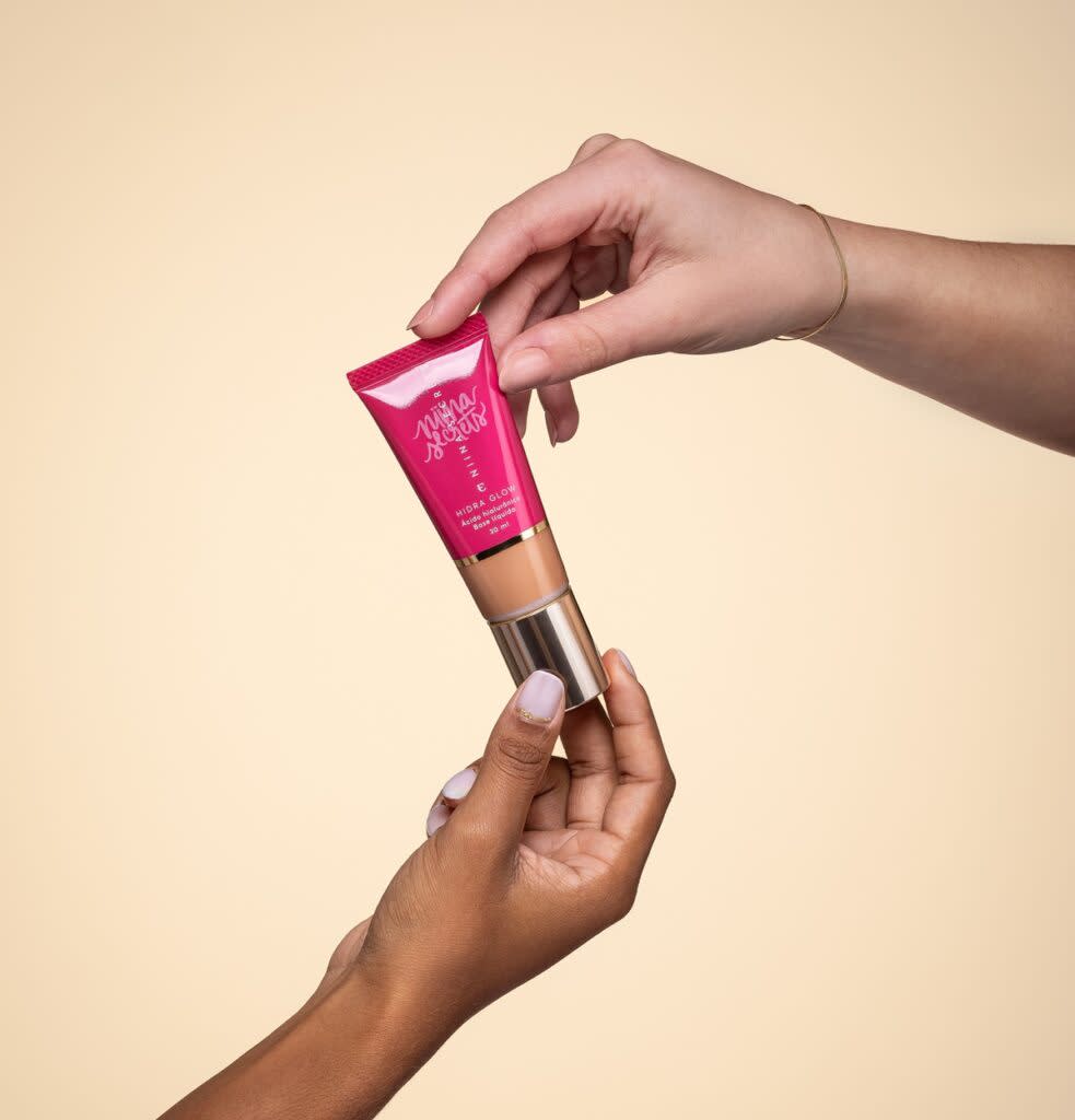 Base hidra glow de Niina Secrets sendo segurada por duas mãos