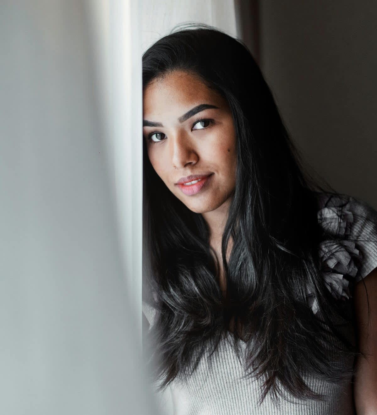 Mulher de cabelo longo escuro e liso olhando para a câmera