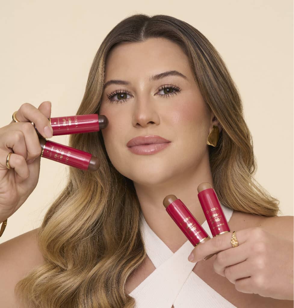 Niina segurando todos os contorno em stick próximos do rosto