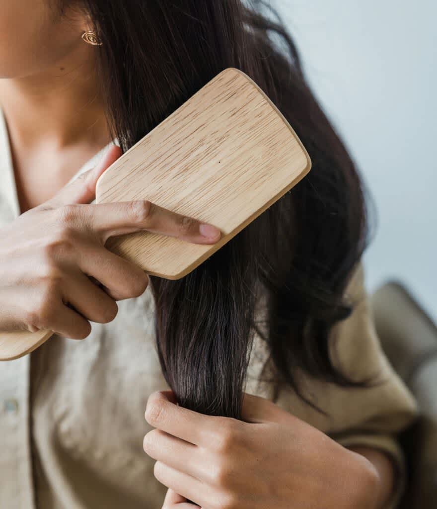 Mulher penteando o cabelo com escova