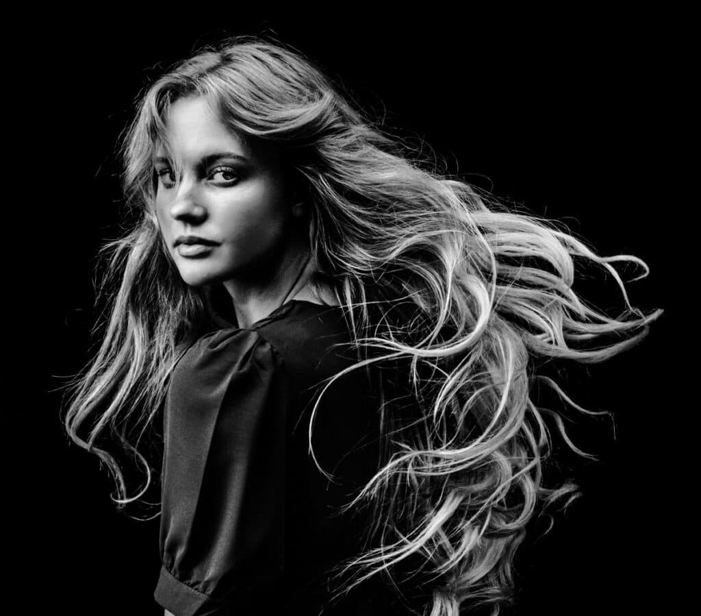 Mulher de cabelos longos olhando para a câmera