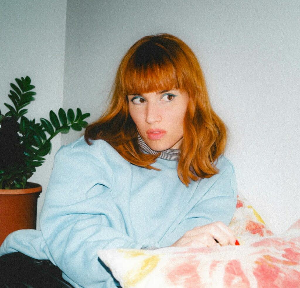 Mulher ruiva com franja frontal e cabelo liso