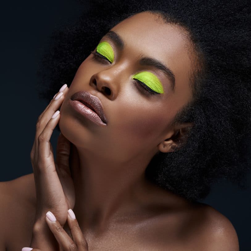 Mulher usando maquiagem neon na cor verde limão