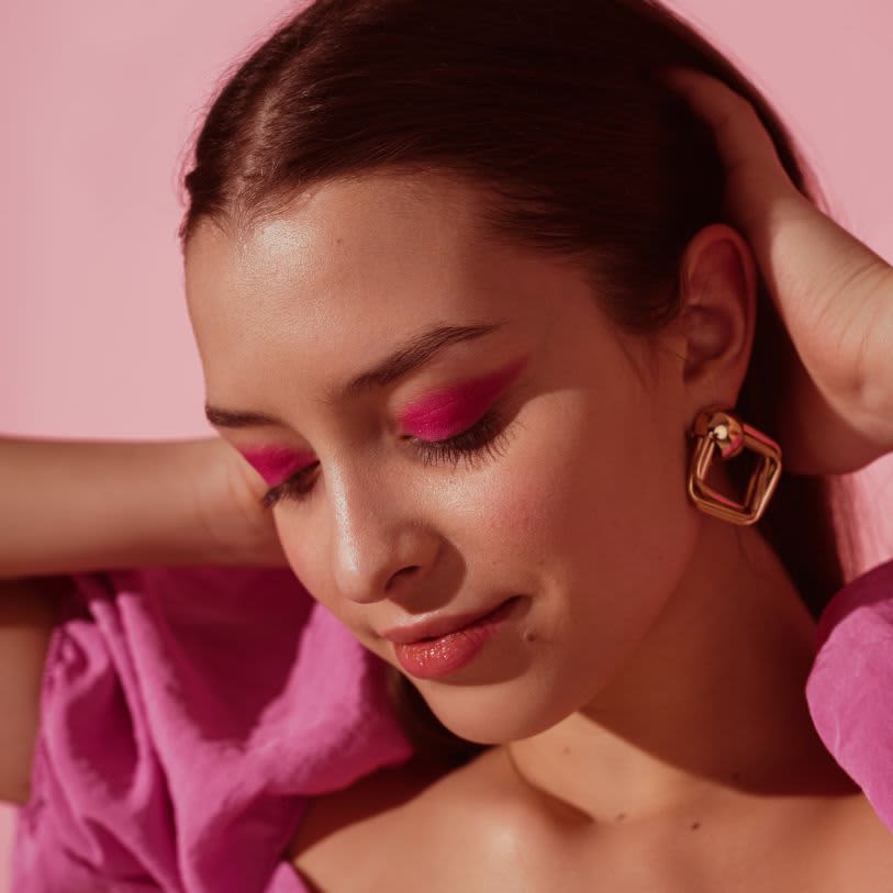 Mulher usando maquiagem cor rosa