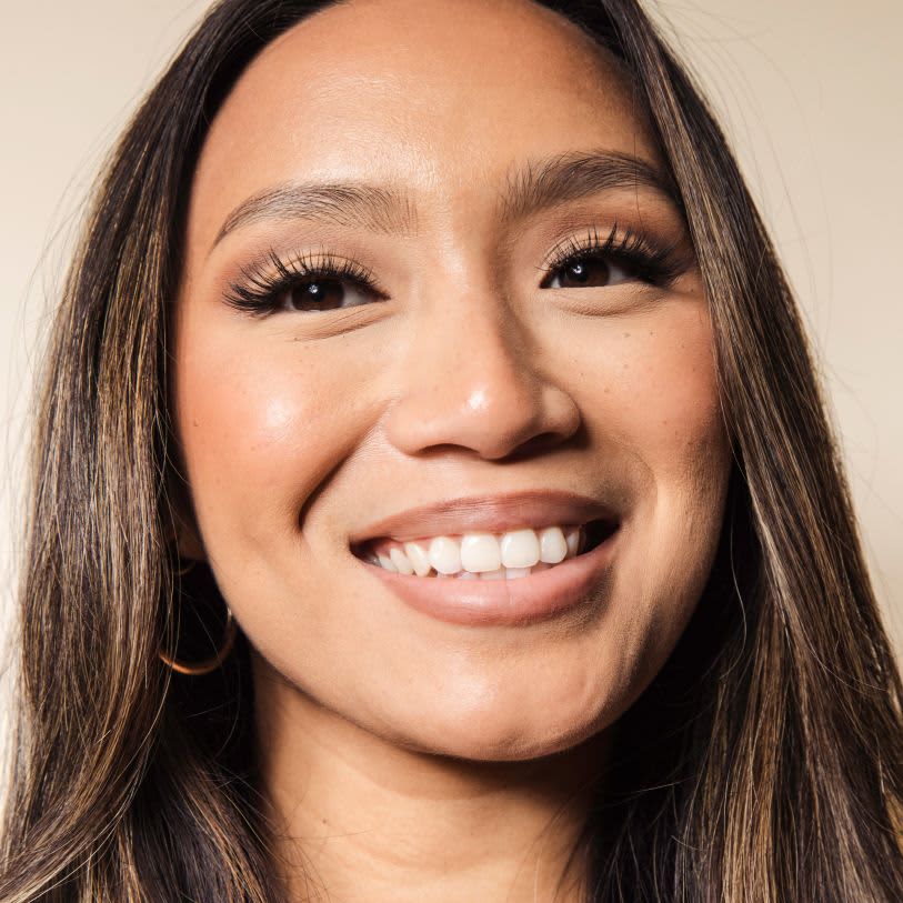 Mulher usando maquiagem em tons neutros e cílios postiços