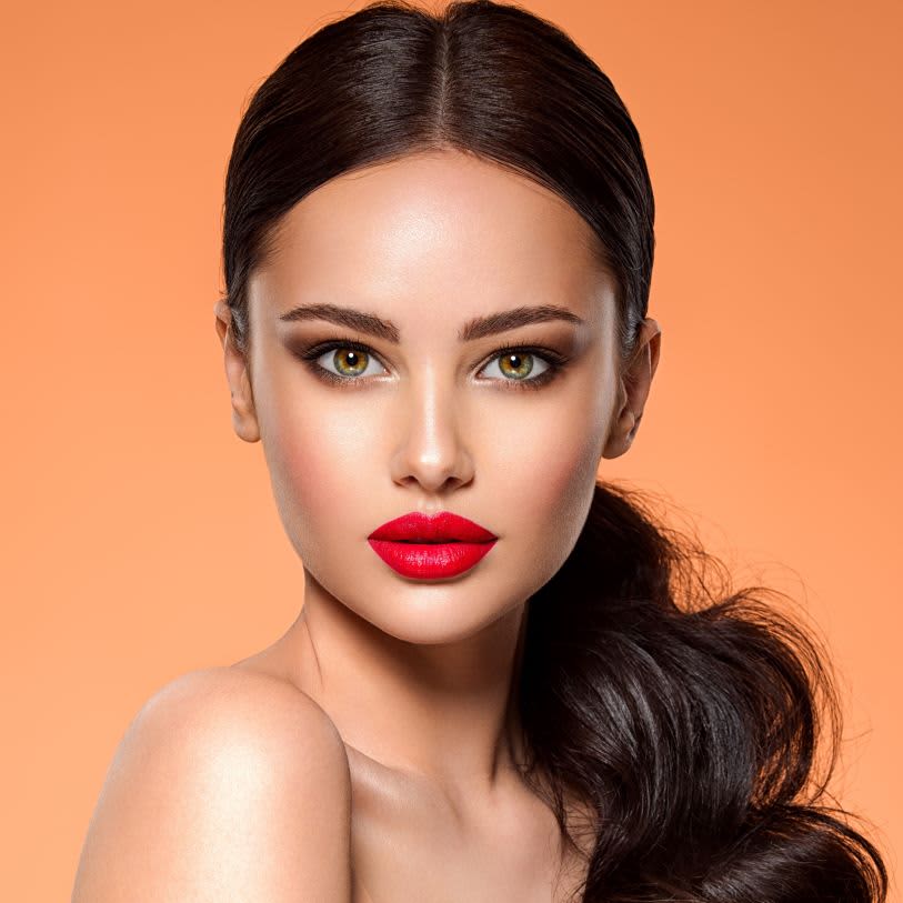 Mulher usando maquiagem com batom vermelha