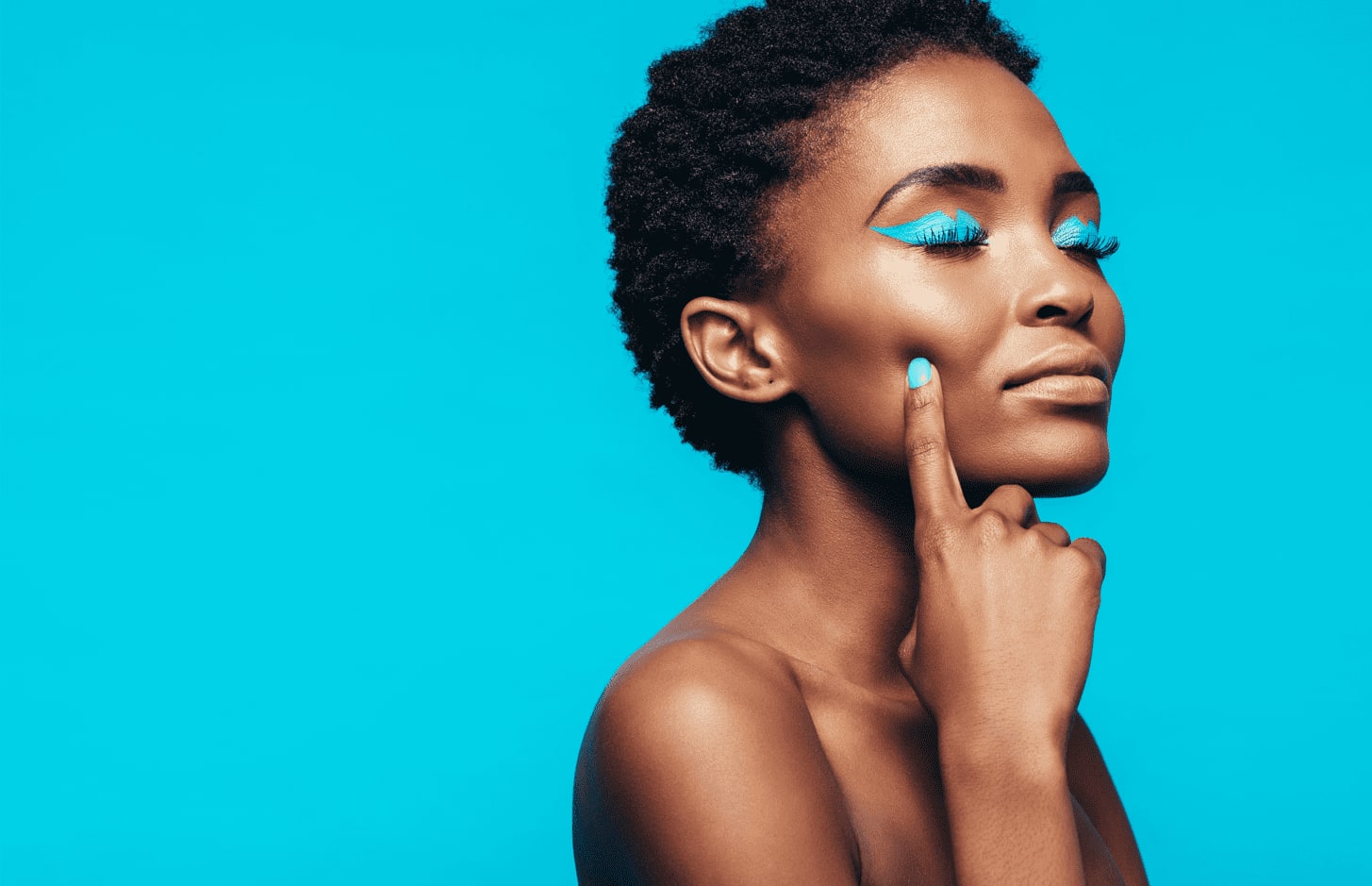 Imagem de mulher com delineado azul e unhas pintadas na mesma cor