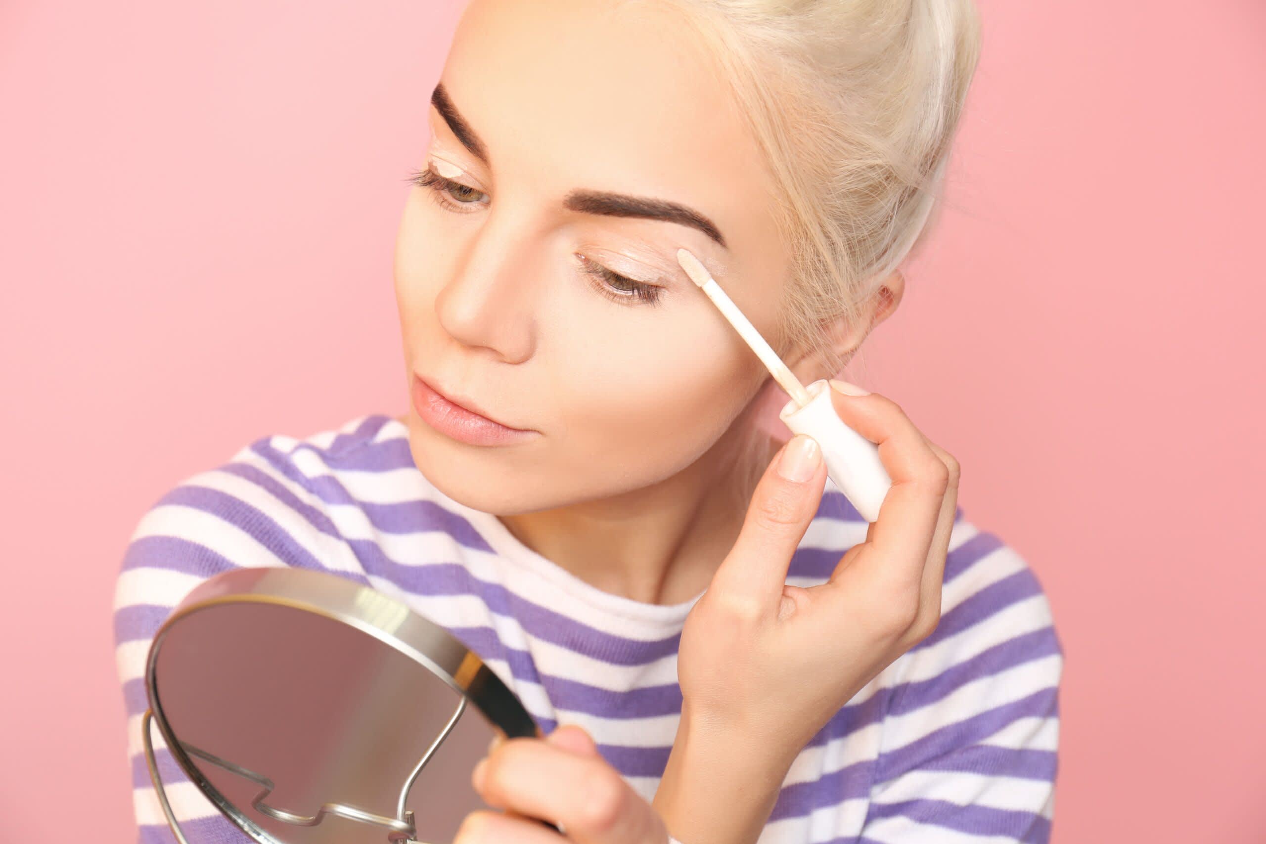 Imagem de mulher aplicando corretivo na pálpebra