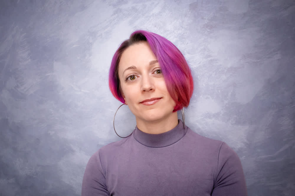 Imagem de mulher com cabelo colorido e corte assimétrico