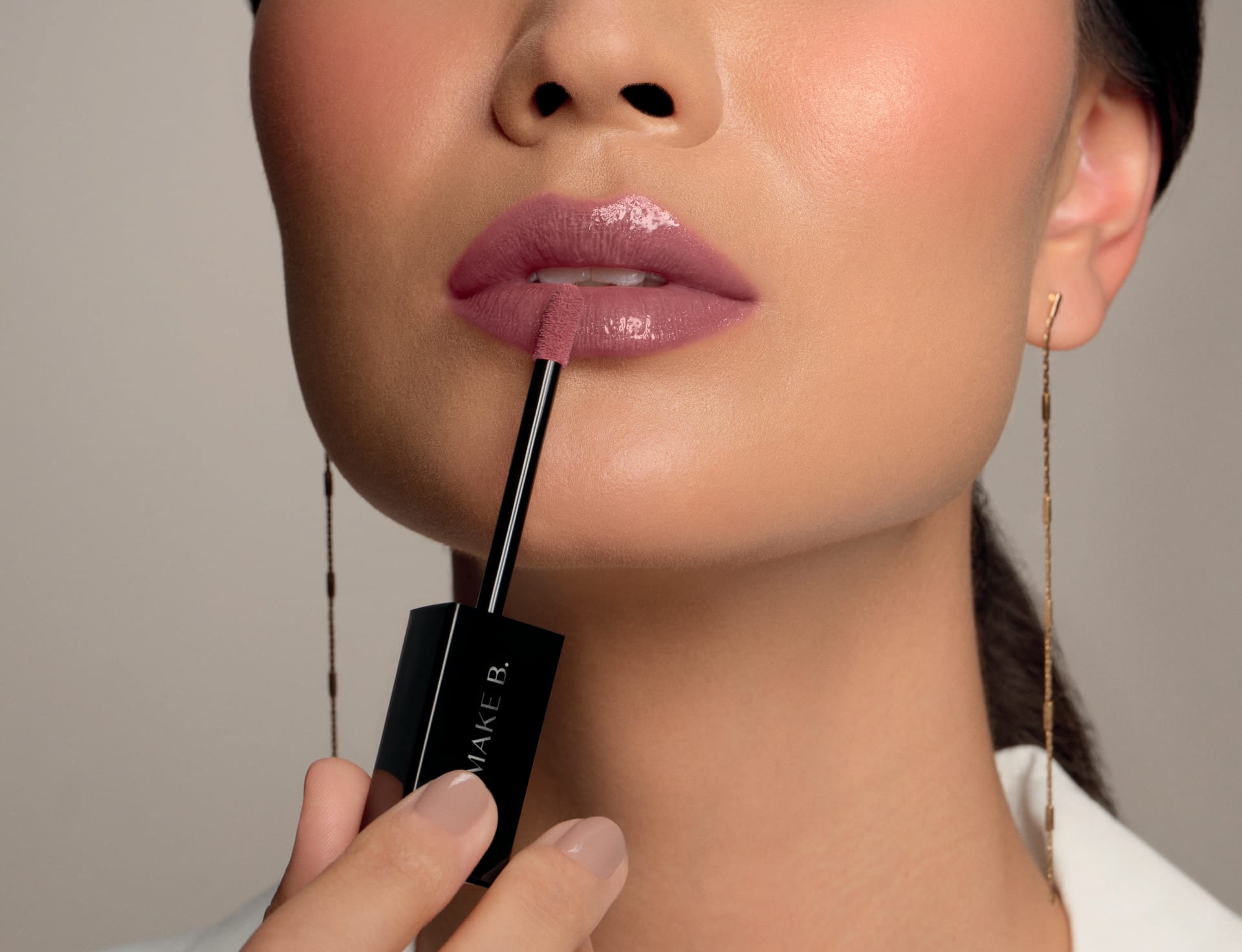 Imagem de mulher aplicando gloss