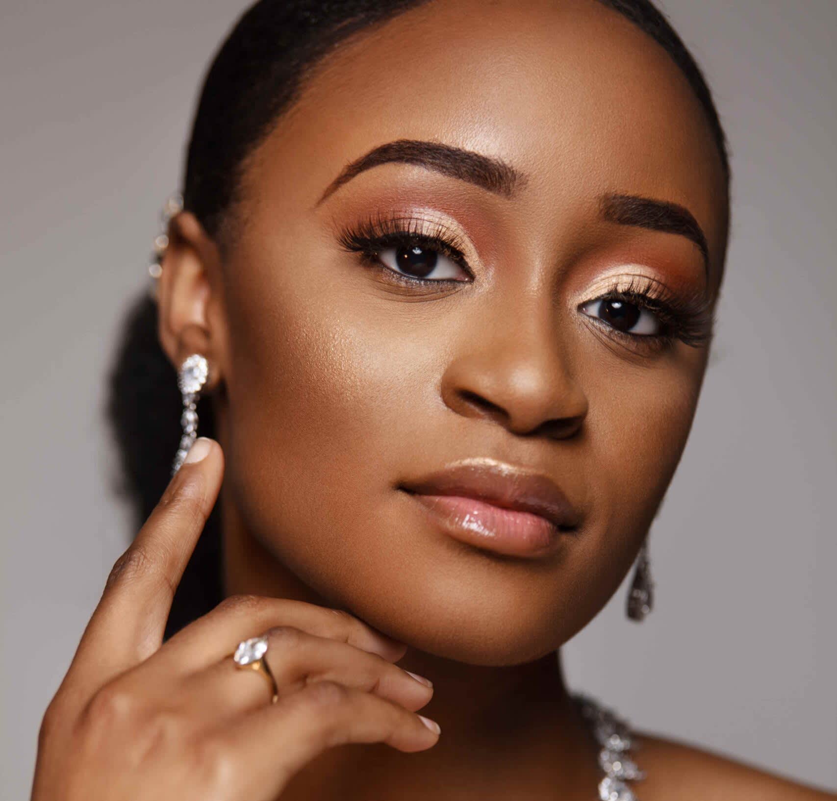 Mulher negra maquiada com olhos delineados por lápis de olho