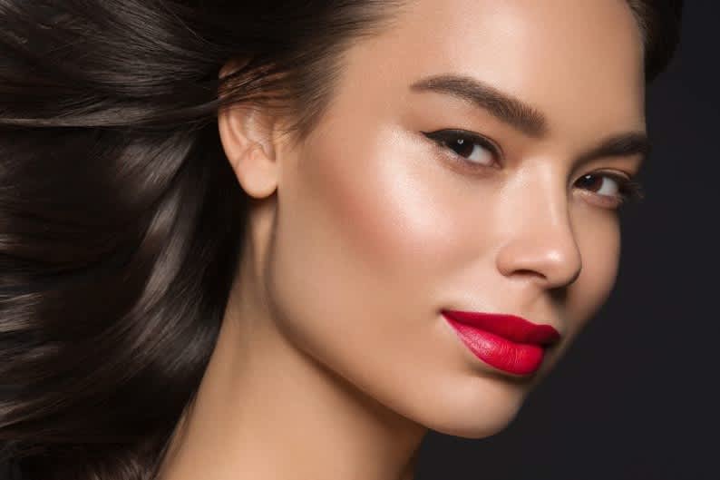 Mulher branca maquiada com batom vermelho