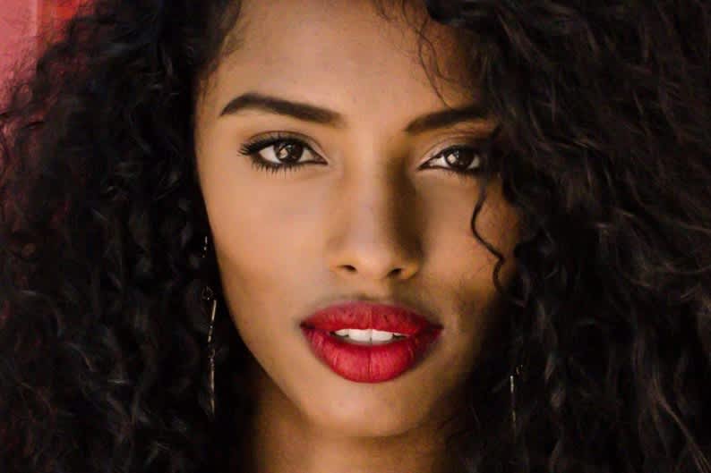 Mulher negra maquiada com batom vermelho