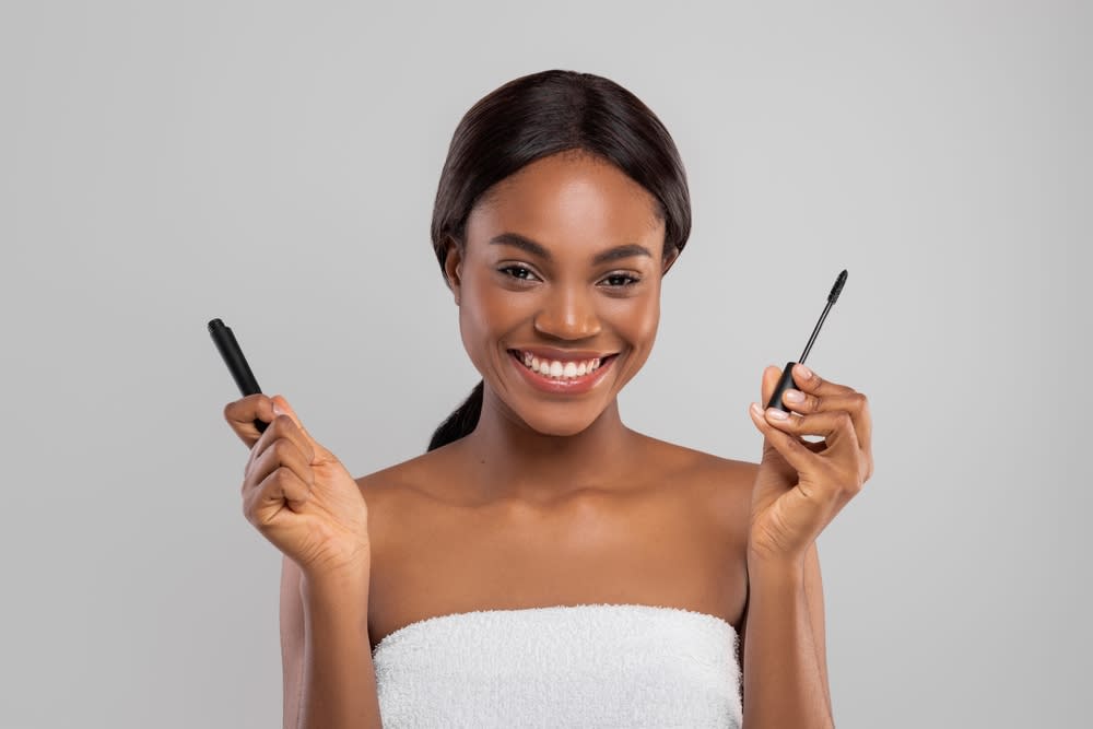 Mulher sorridente usando máscara de cílios