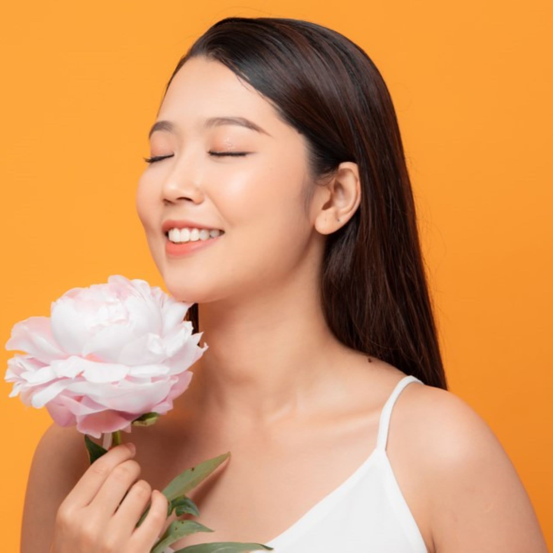 Mulher sentindo o cheiro de flores