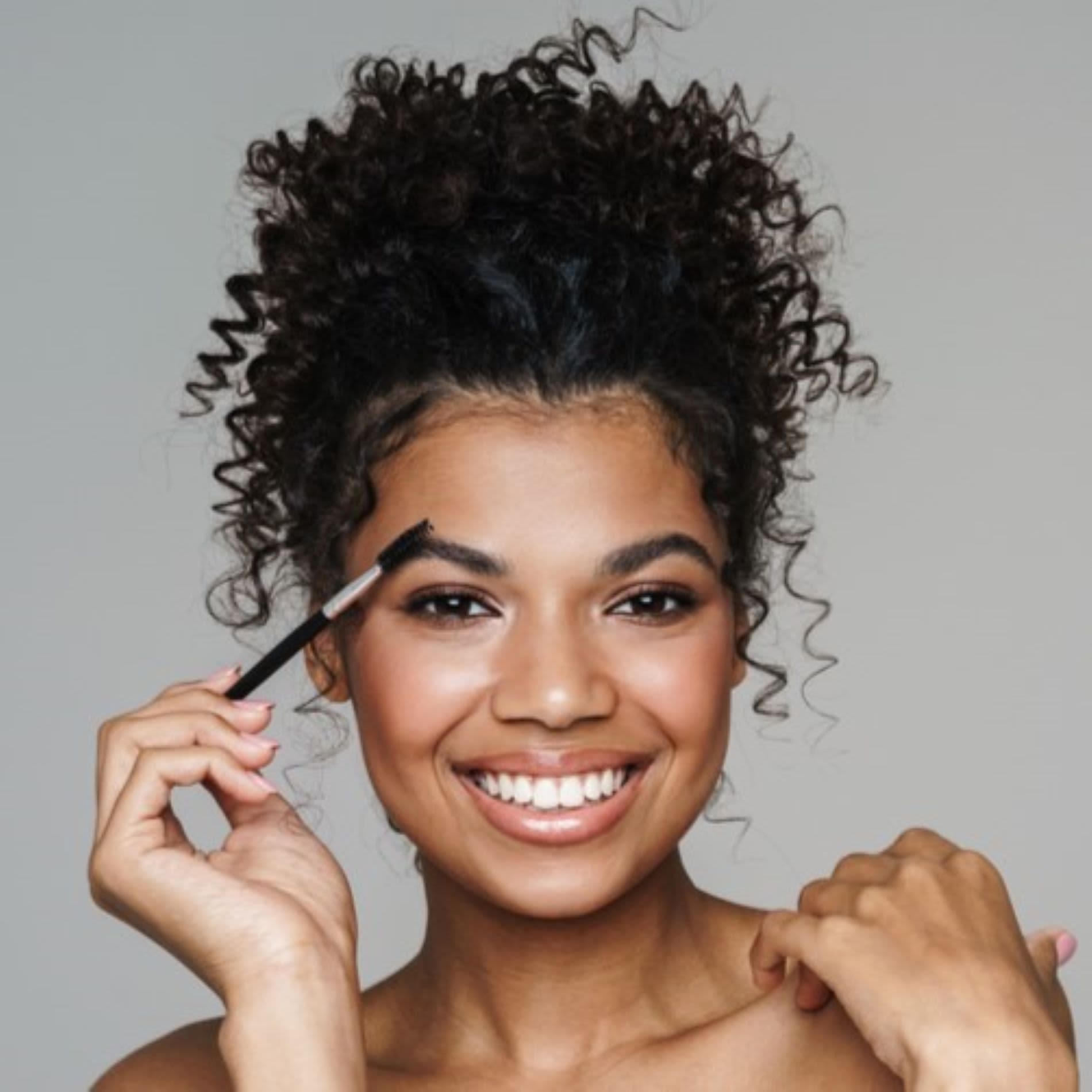 Mulher penteando sua sobrancelha com pincel de maquiagem