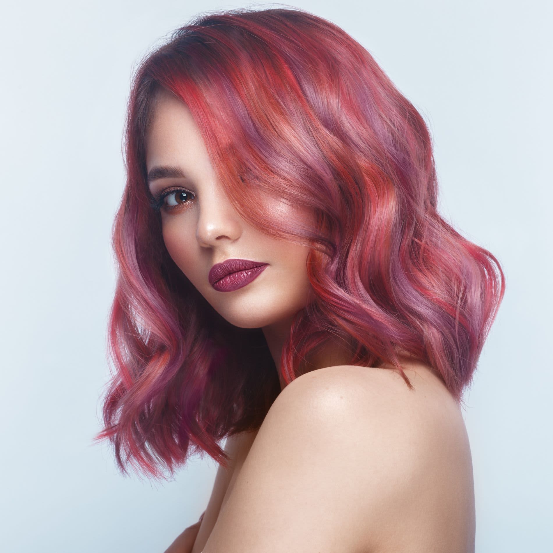 Mulher branca de cabelo colorido na cor rosa e ondulado