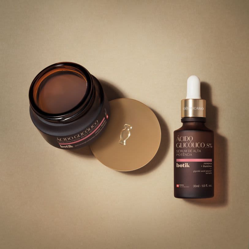 Frasco de sérum facial Ácido Glicólico 8% e pote de máscara facial Ácido Glicólico, ambos da linha Botik de O Boticário, dispostos sobre uma superfície bege.