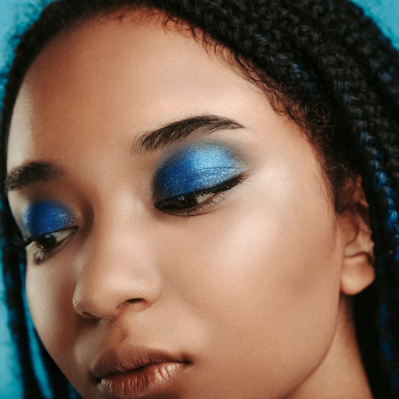 Mulher usando sombra de olho na cor azul